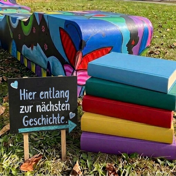 bunt gestaltete Bank mit einem Bücherstapel davor
