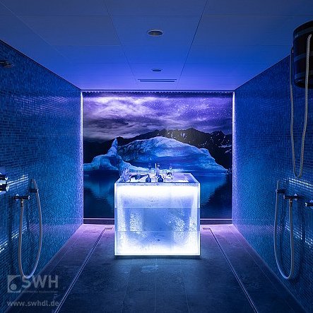 blaustrahlender Eisbrunnen im Bereich der Duschen