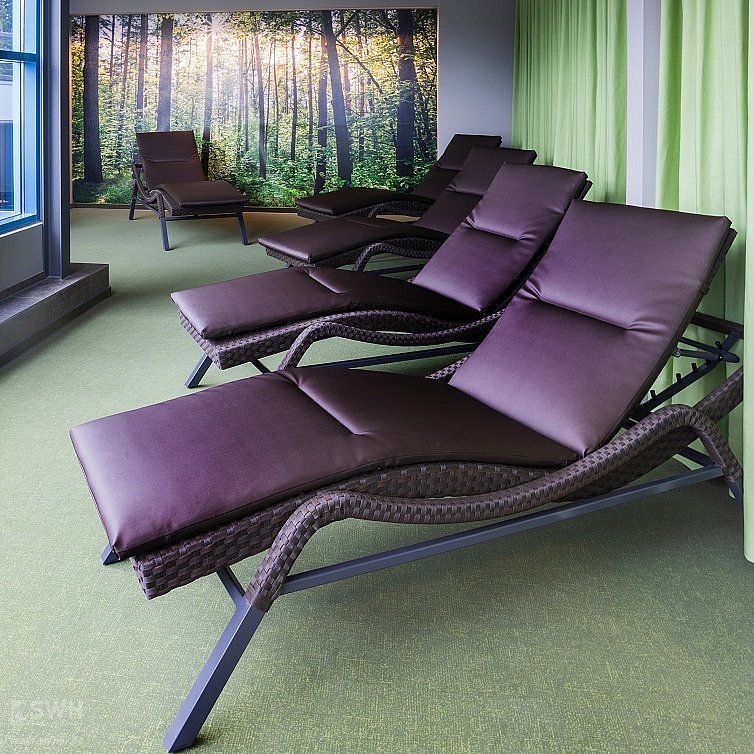 Ruheraum mit Liegen und Waldposter im Hintergrund