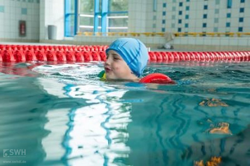 Ein Kind lernt im Wasser schwimmen 