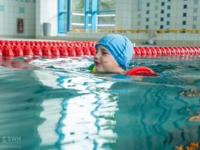 Ein Kind lernt im Wasser schwimmen 