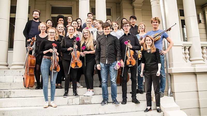 Musiker der Sommer-Musik-Akademie stehen mit Ihren Instrumenten auf der Treppe vor der Villa Albrecht